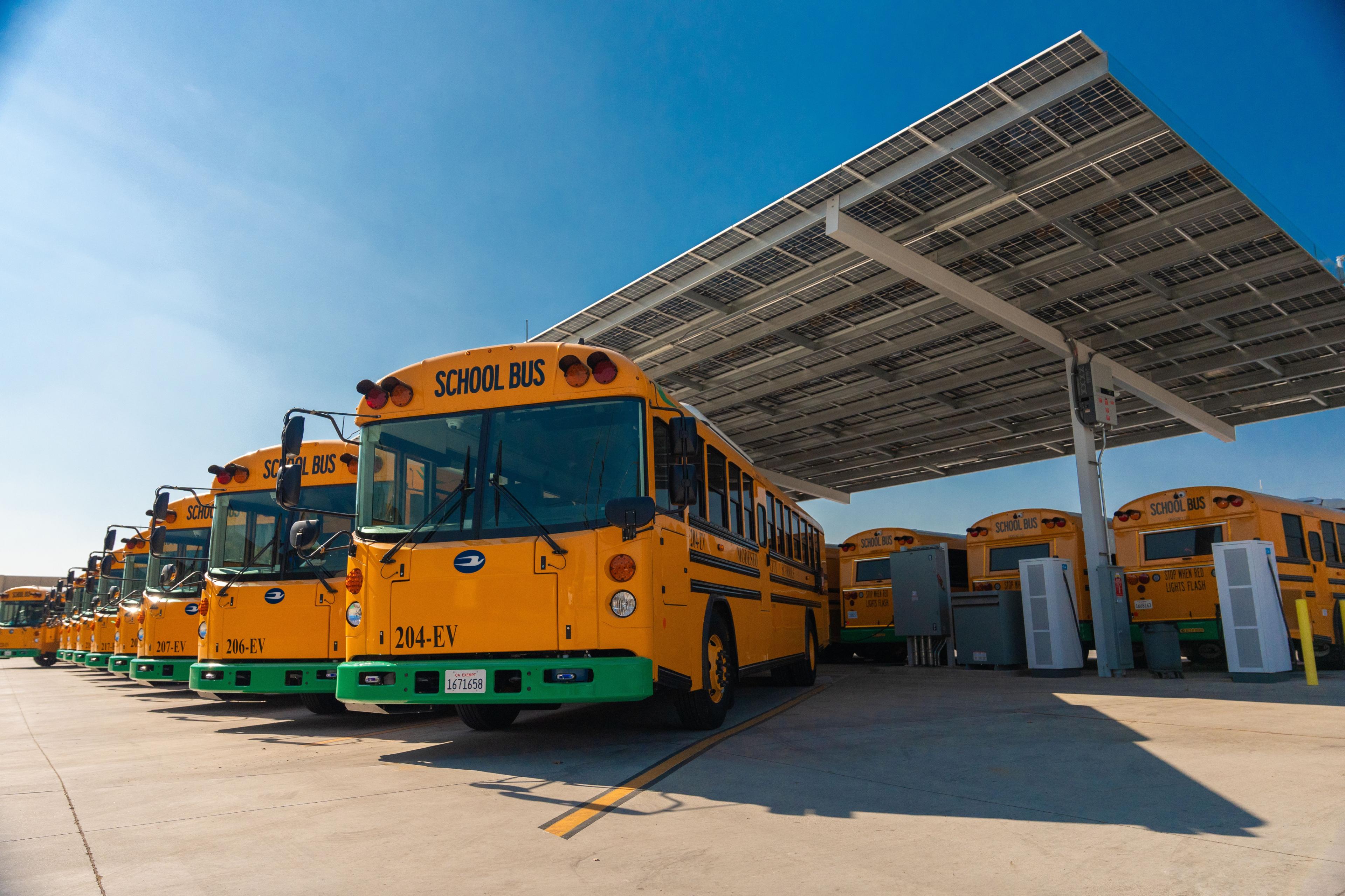 Electric school buses charging under a solar canopy at modesto city schools depot