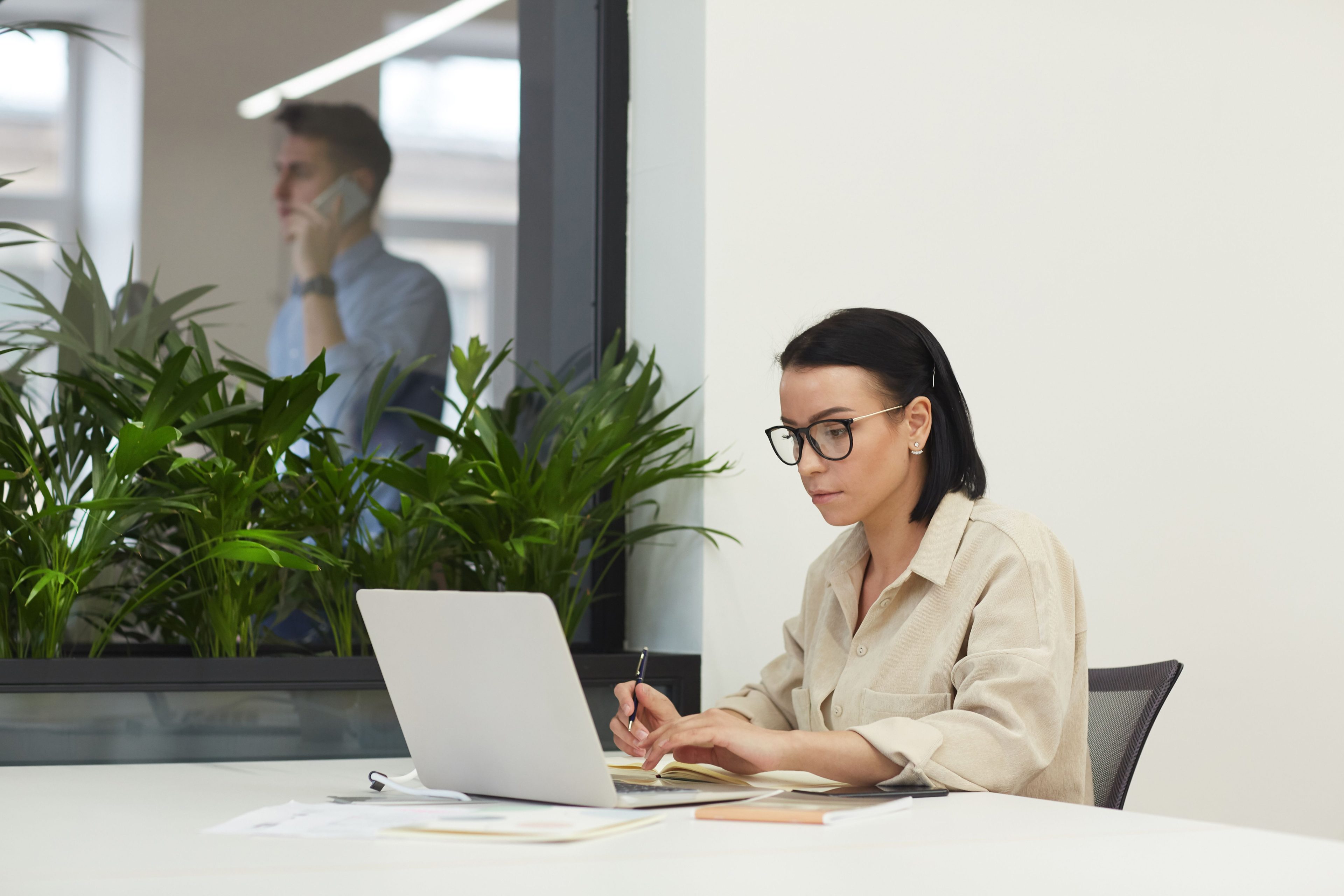 Frau arbeitet am Laptop und macht sich Notizen