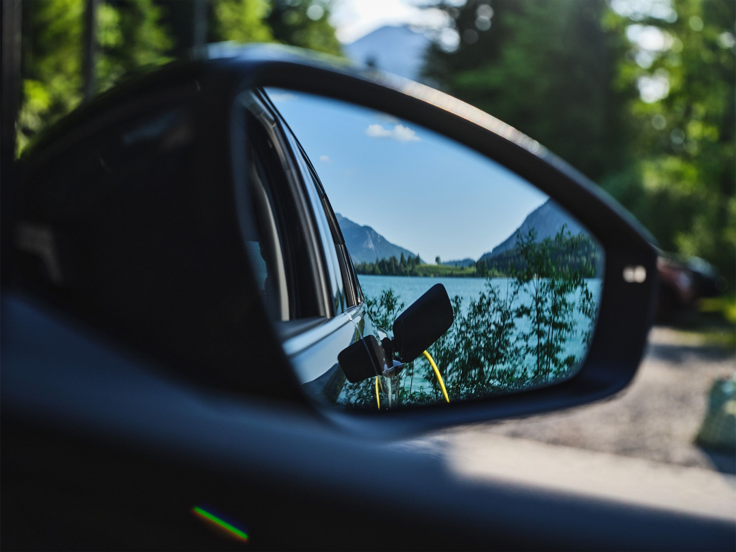 Seitenspiegel eines Autos indem sich die Ladebuchse spiegelt