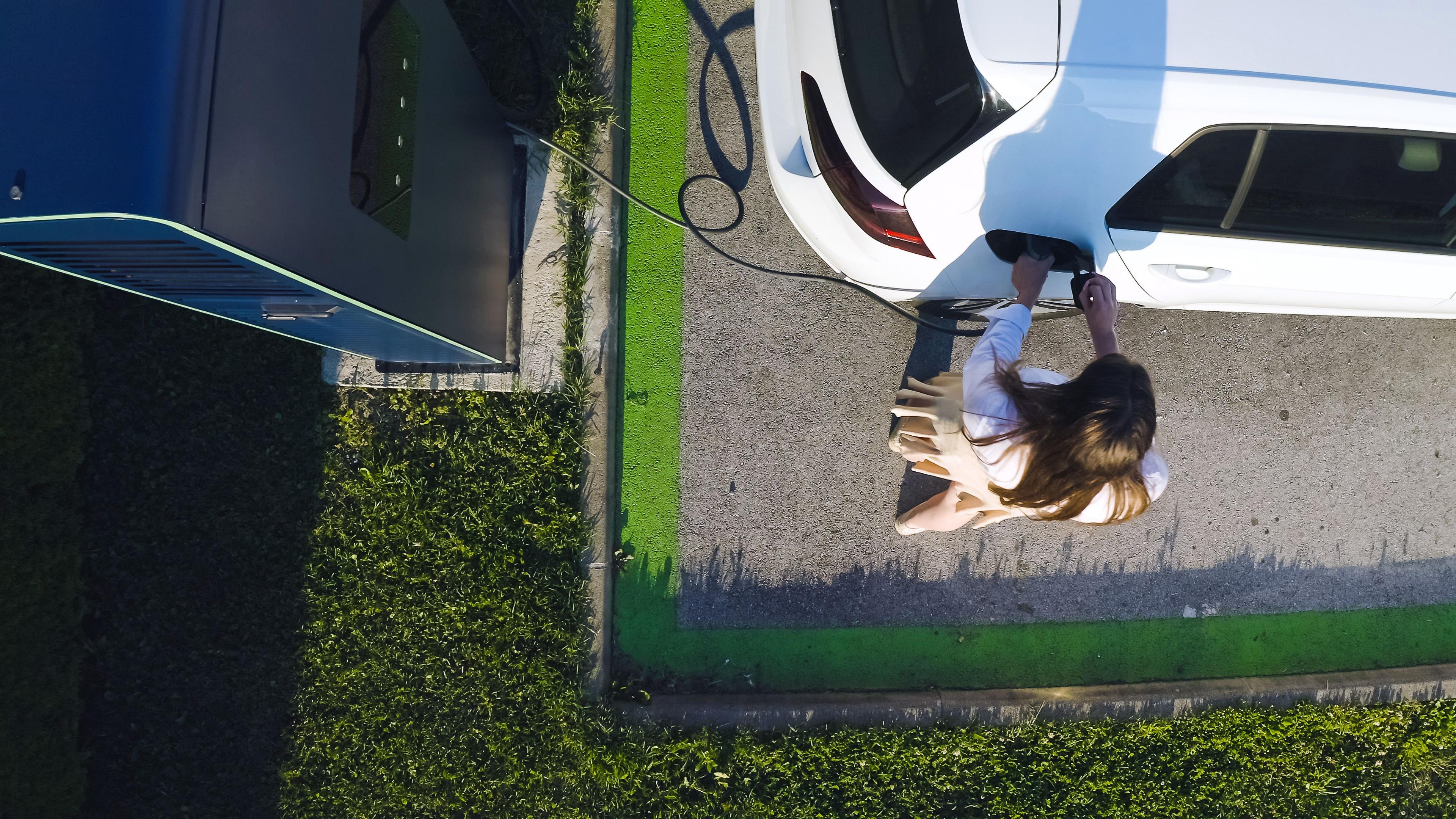 Woman charging her electric car at DC fast charger