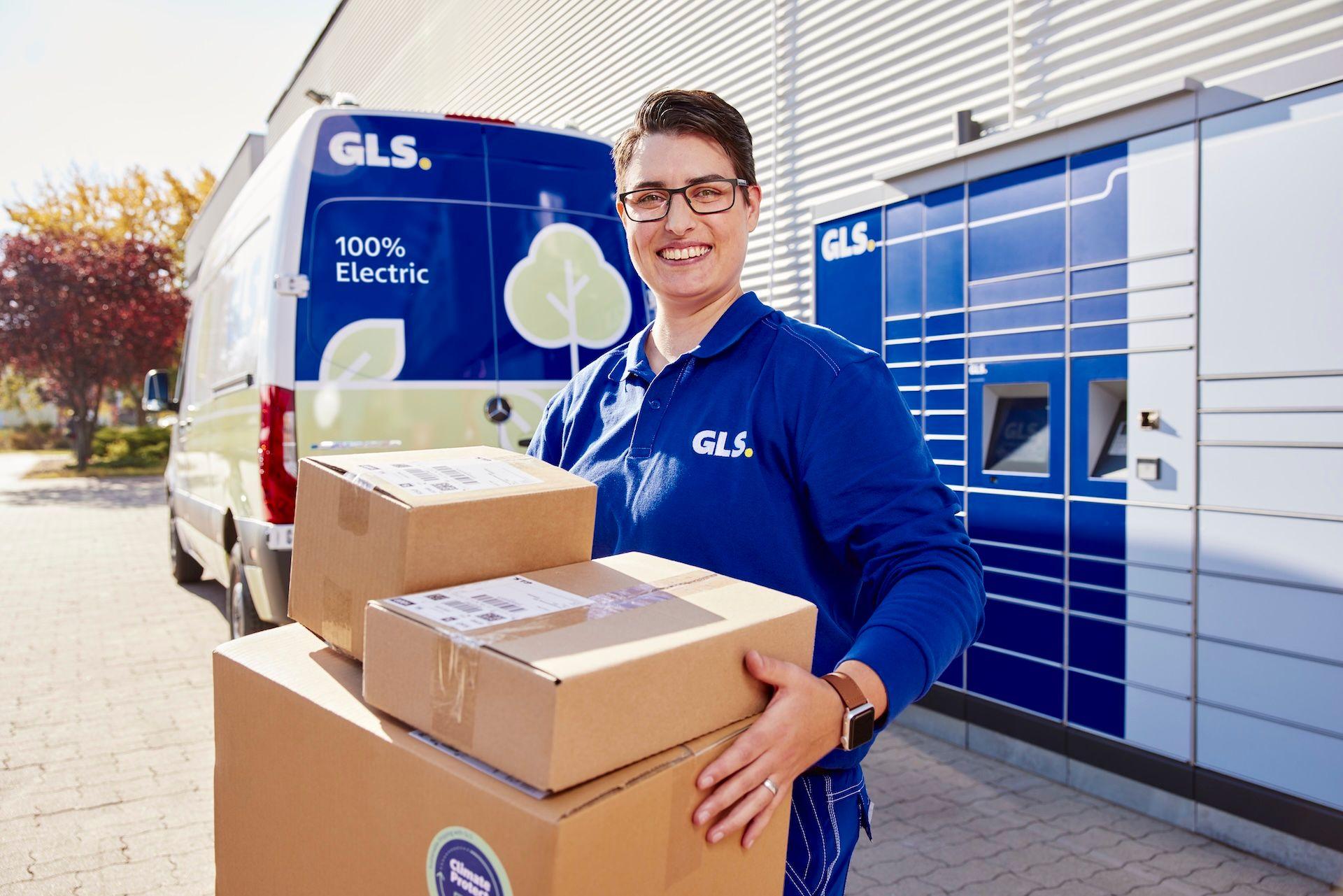 Lieferantin von GLS mit Paketen, im Hintergrund sieht man den E-Transporter
