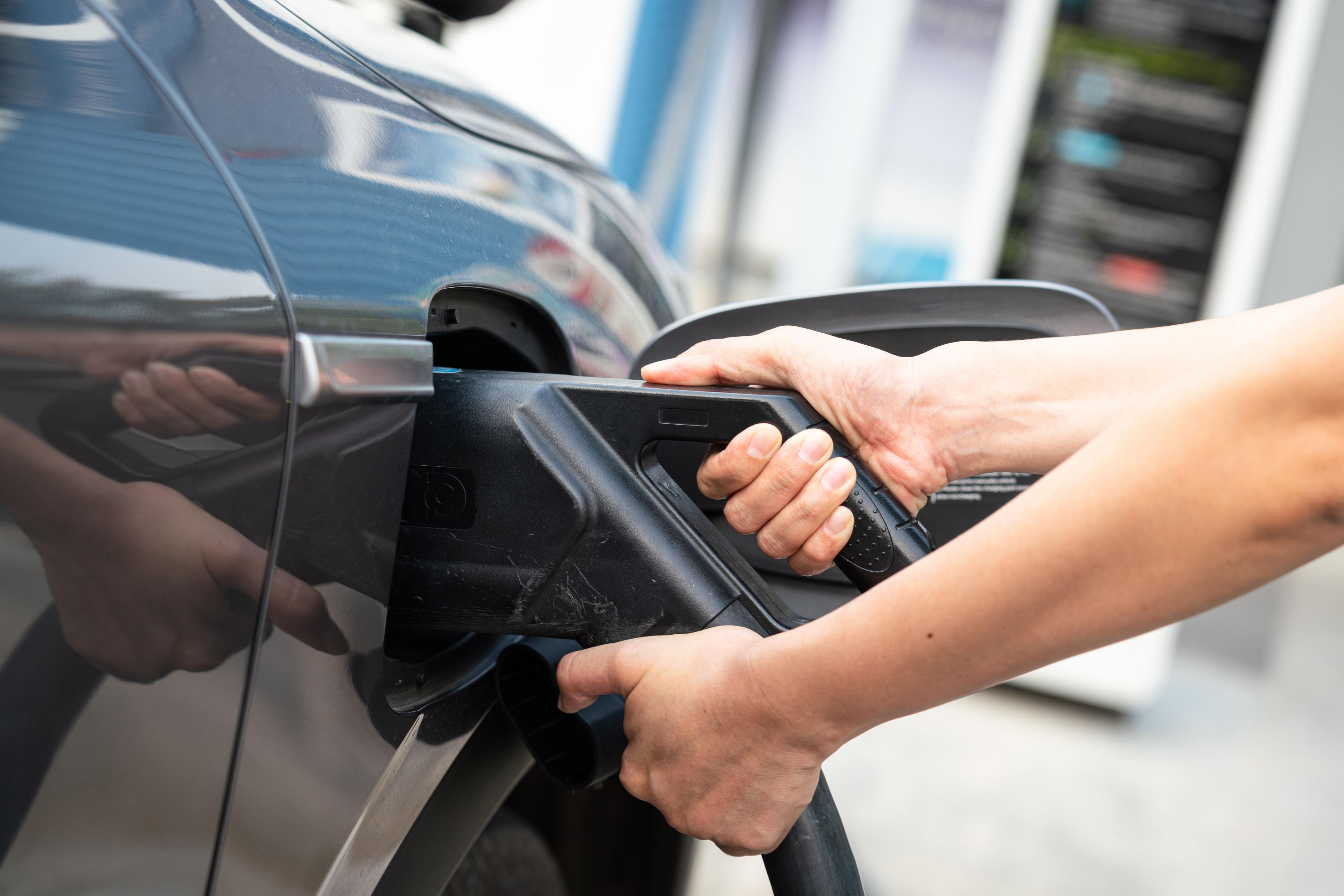 Stecker von Schnellladestation wird an E-Auto gesteckt