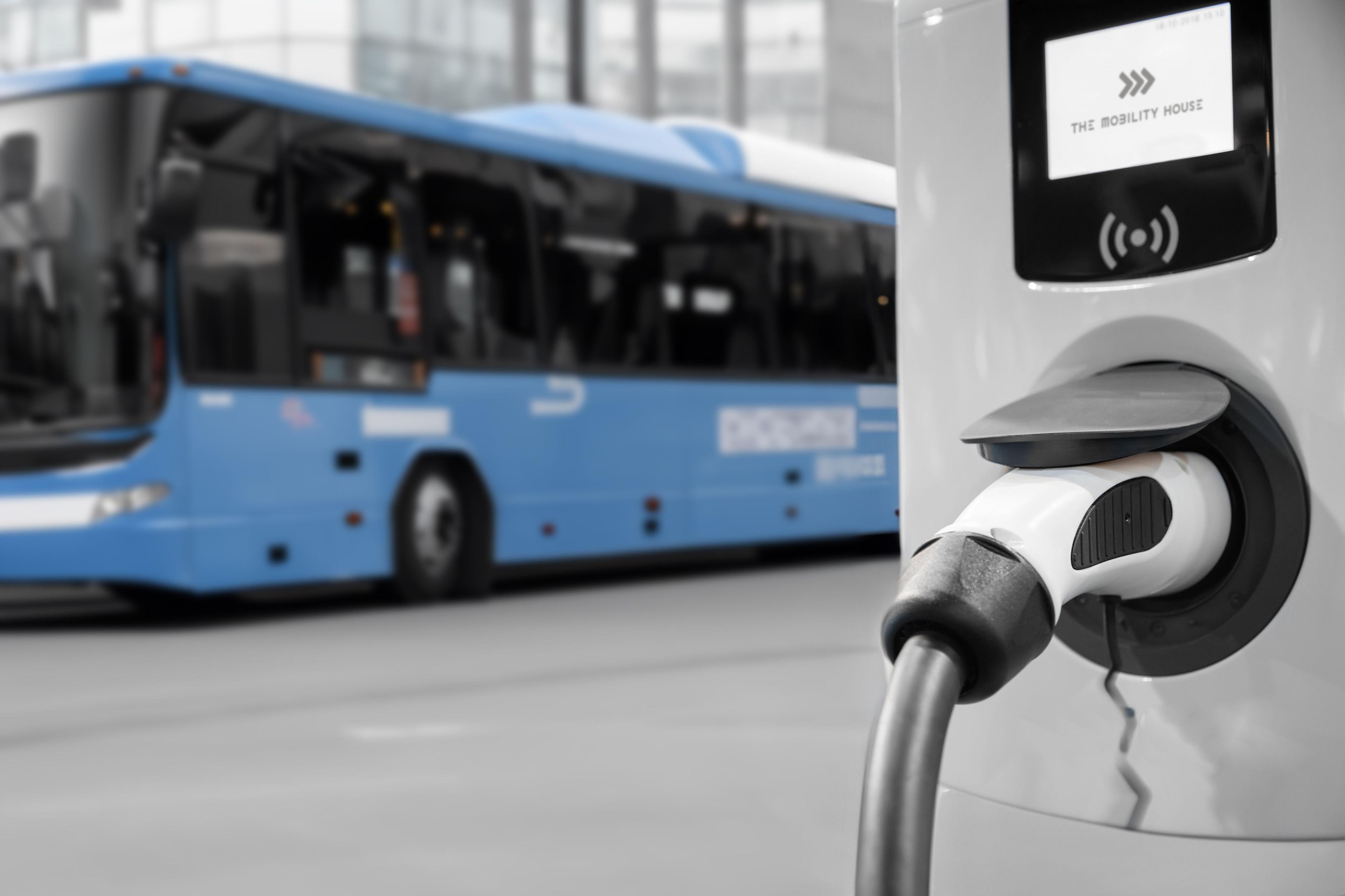 An electric transit bus pulling into an ev charging station