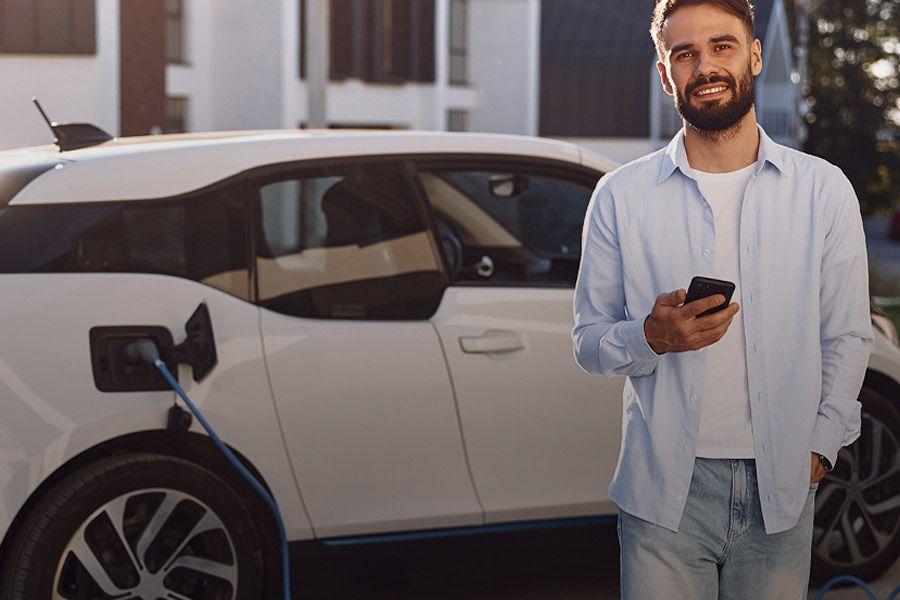 Mann steuert Ladevorgang von BMW i3 mit Smartphone