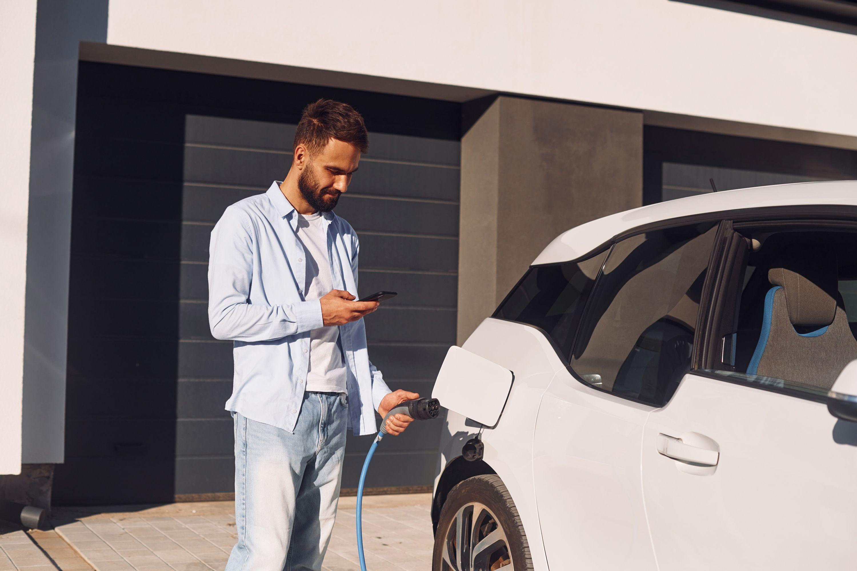 Mann lädt sein E-Auto über die App