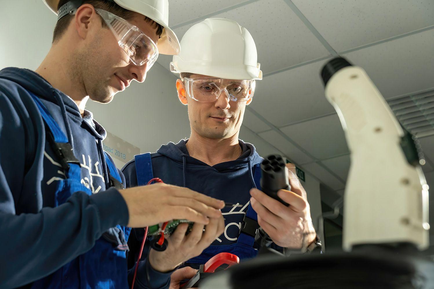 Elektriker prüfen den Stecker einer Ladestation