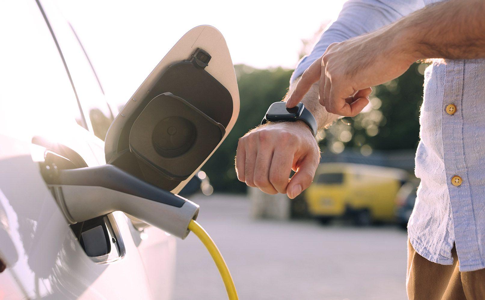 Mann steuert das Laden seines Autos per Smartwatch