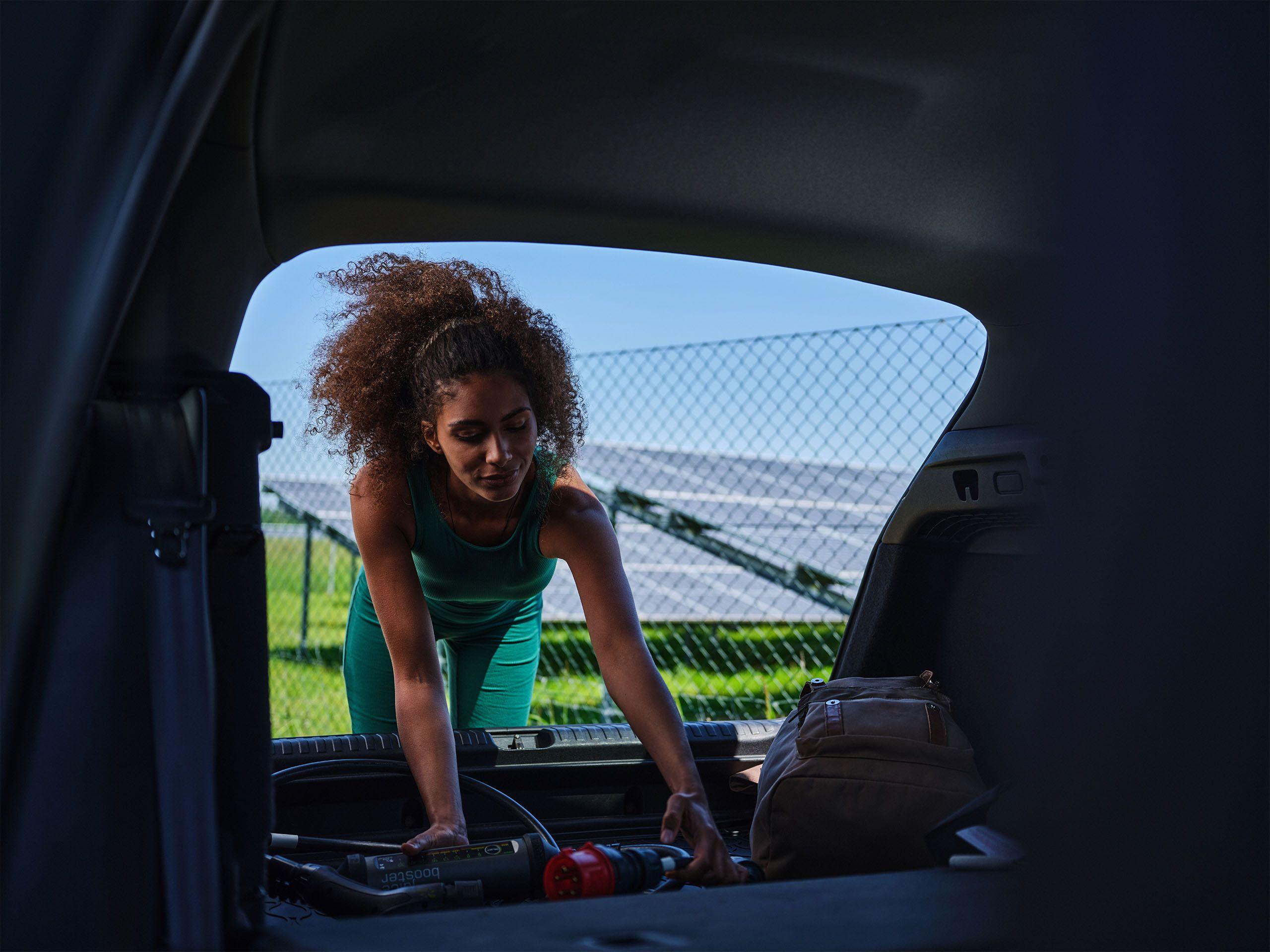 Junge Frau holte mobile Ladestation aus Auto