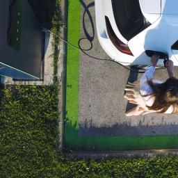 Woman charging her electric car at DC fast charger