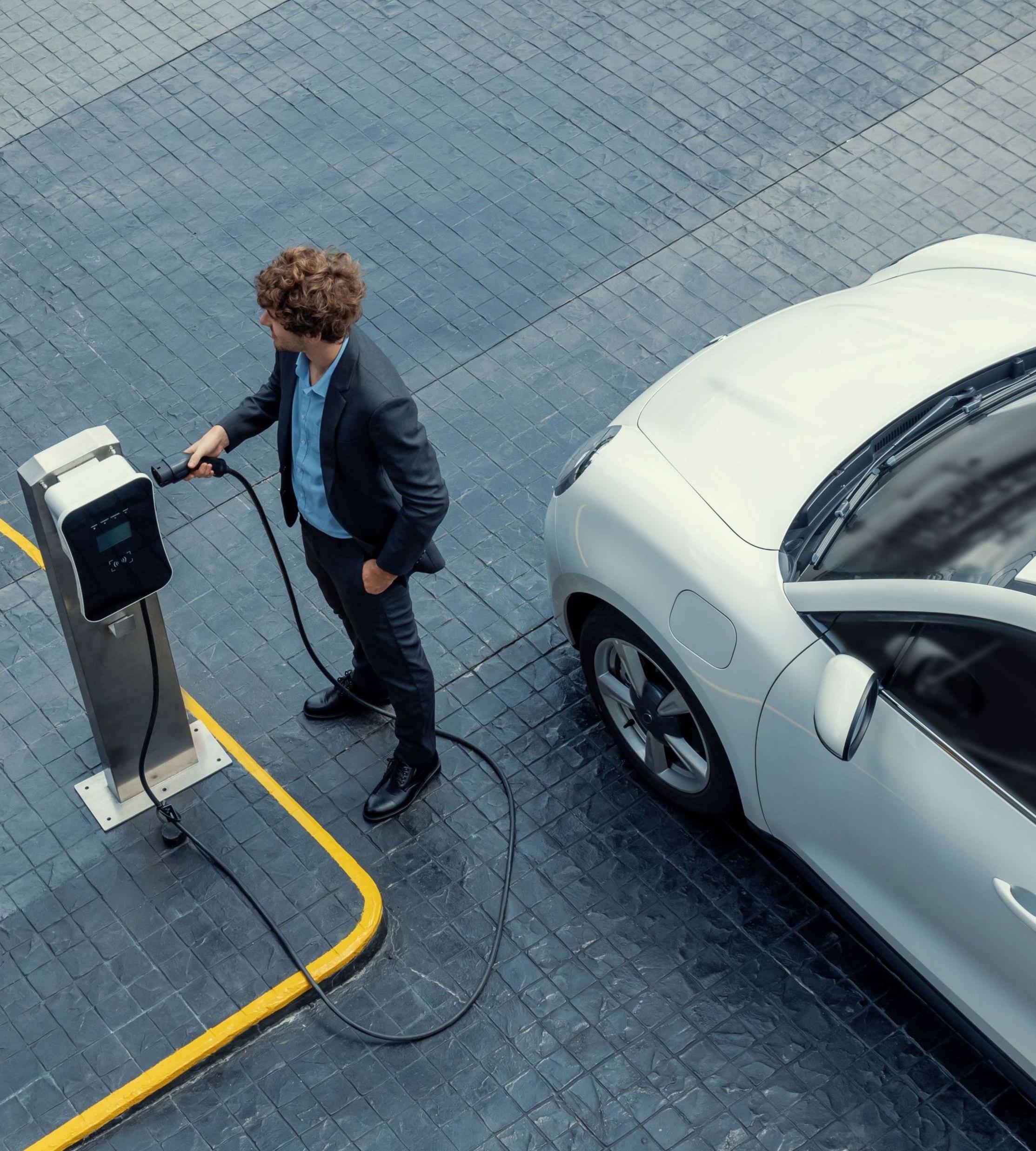 Mann lädt Auto am Arbeitsplatz