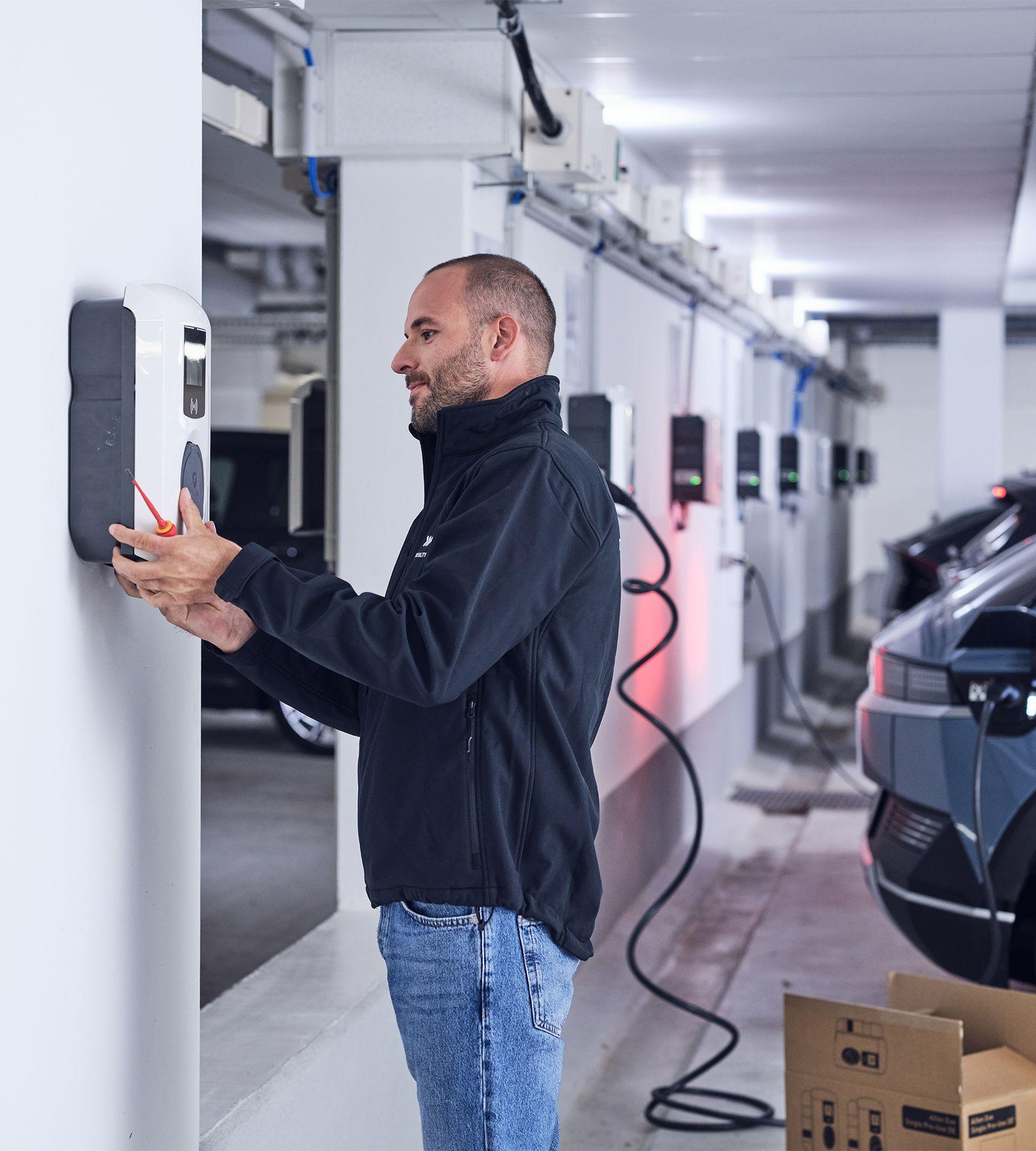 Elektriker montiert Wallbox in Tiefgarage