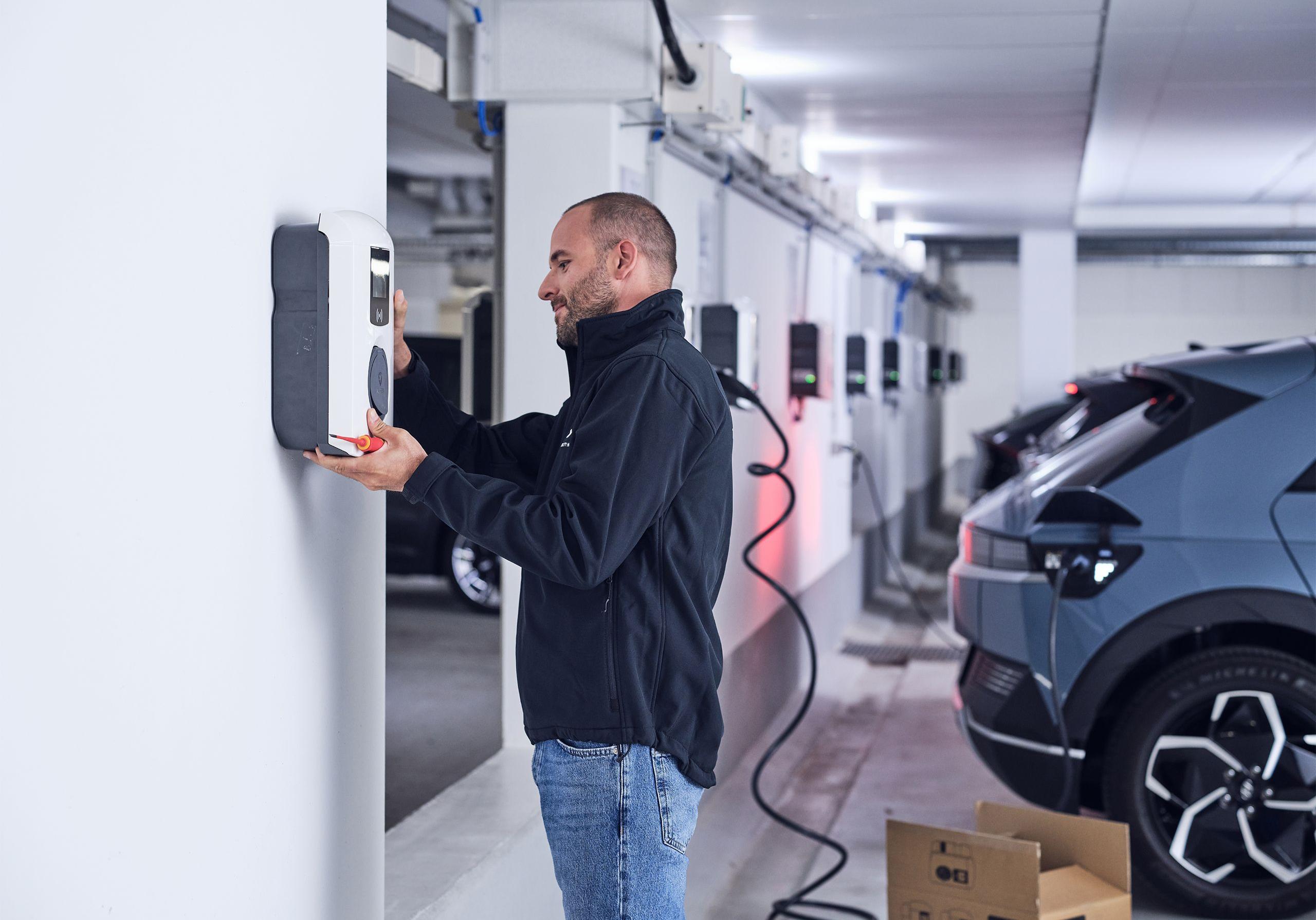 Elektriker montiert Wallbox in Tiefgarage