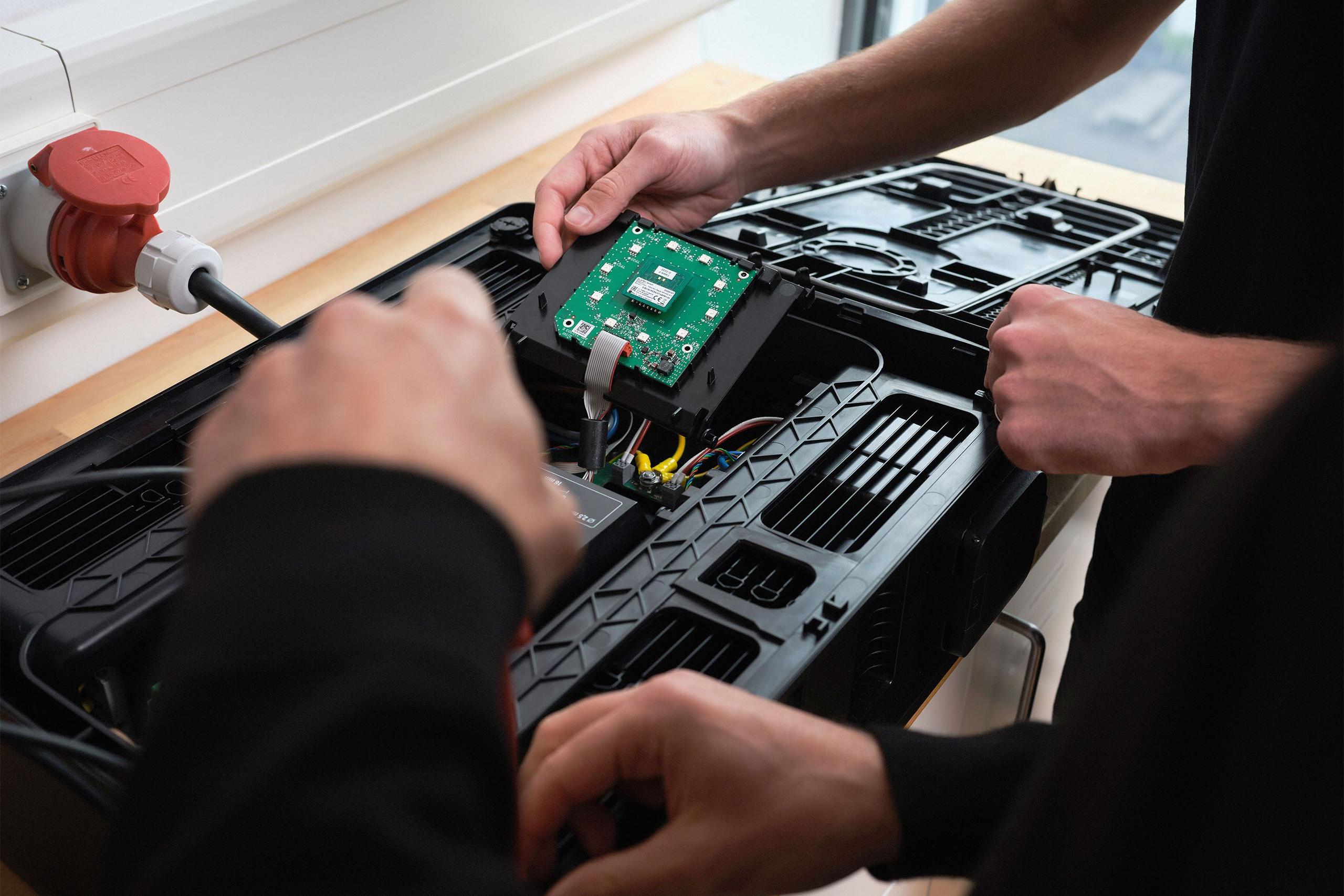 Zwei Maenner arbeiten in der Elektrowerkstatt