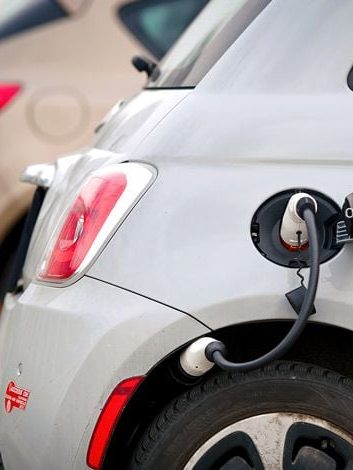 Parkender Elektro-Fiat mit Ladekabel