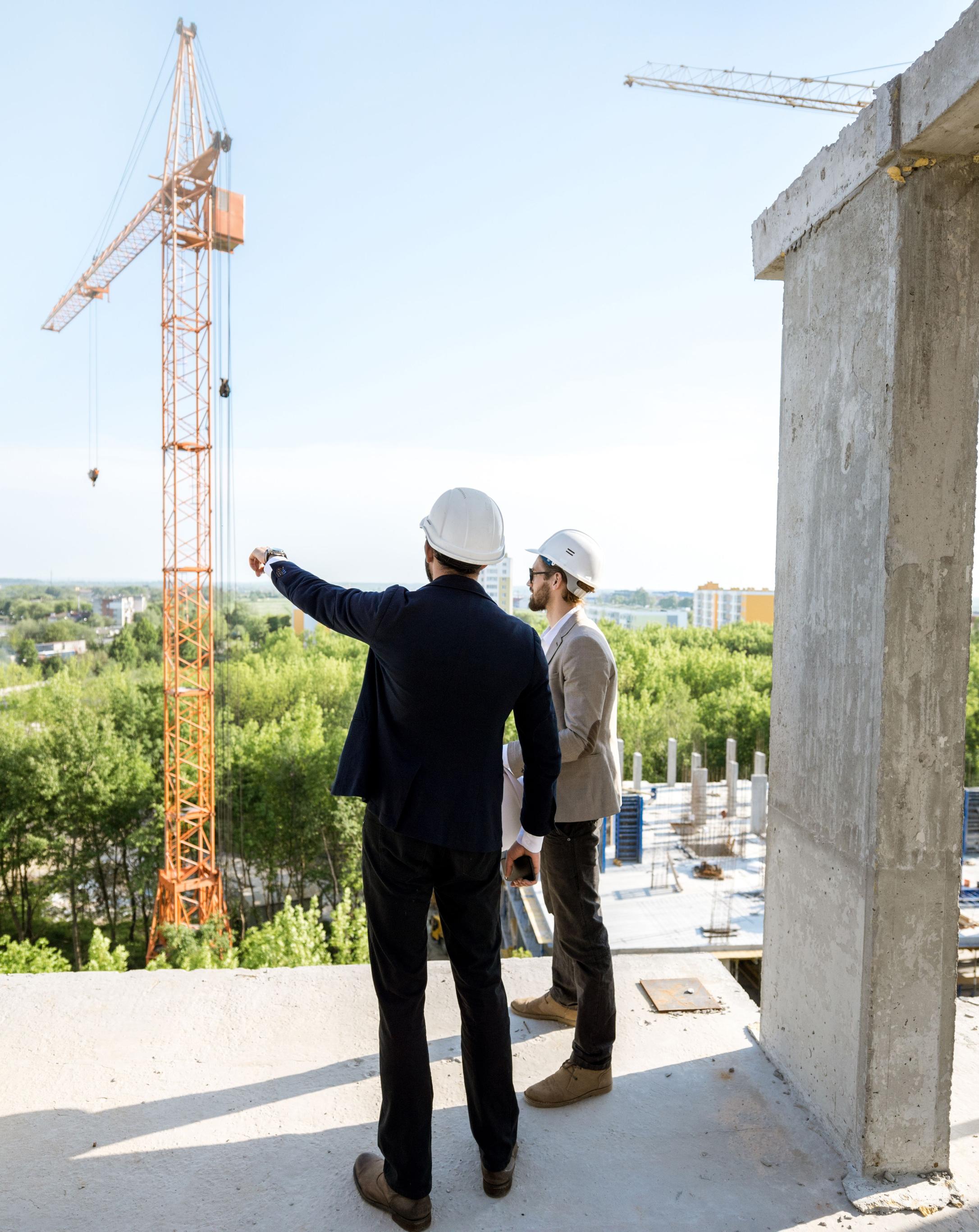 Zwei Männer mit Helmen auf einer Gebäude-Baustelle