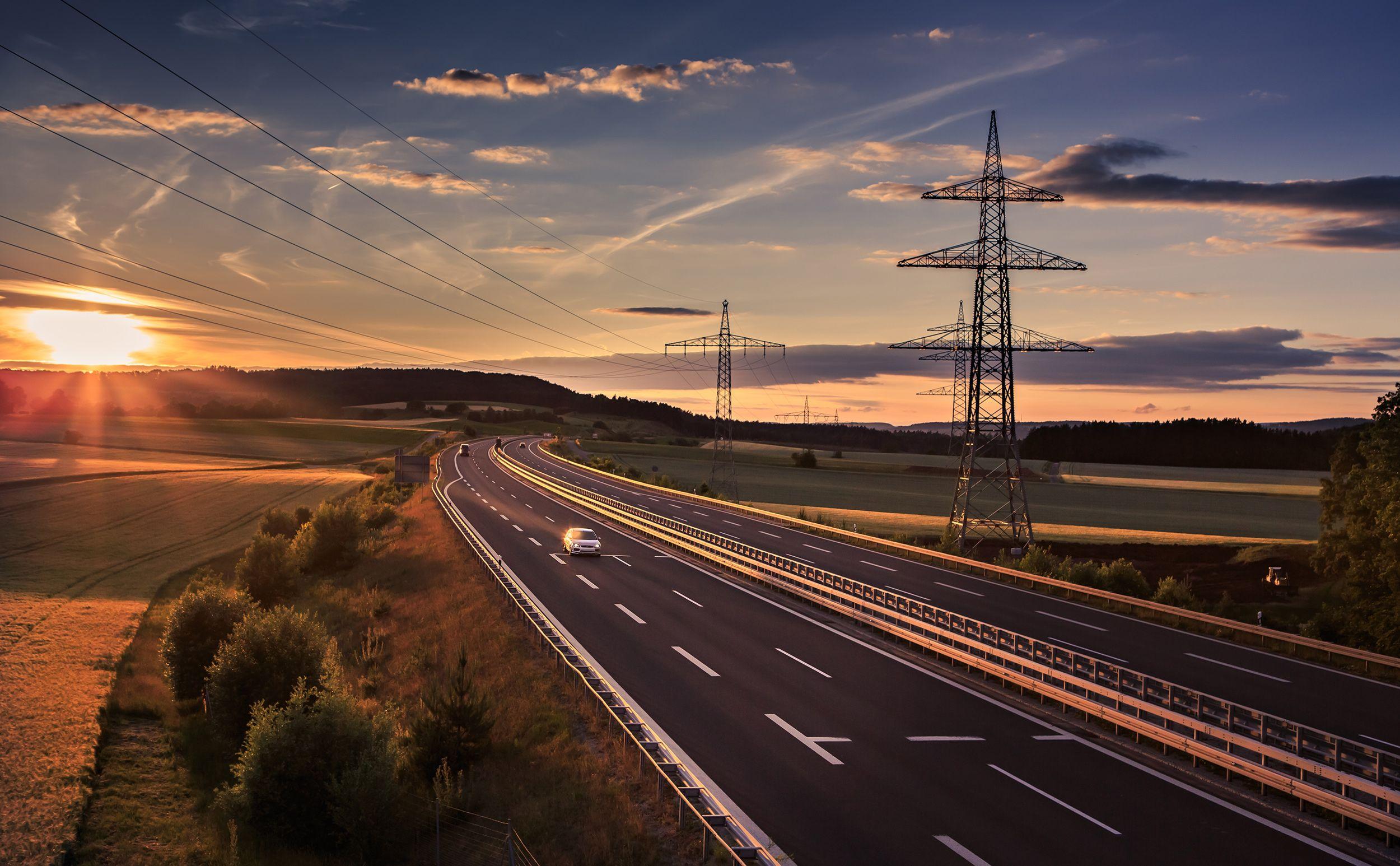 Auto fährt über Autobahn bei Sonnenuntergang