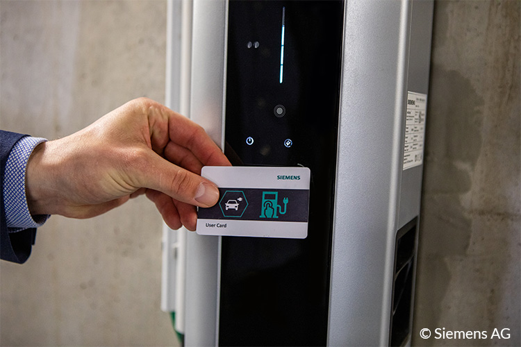 Frau mit RFID Karte an EVBox Ladestation für E-Auto