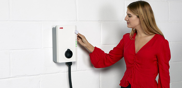 Frau lädt E-Auto an ABB Ladestation 