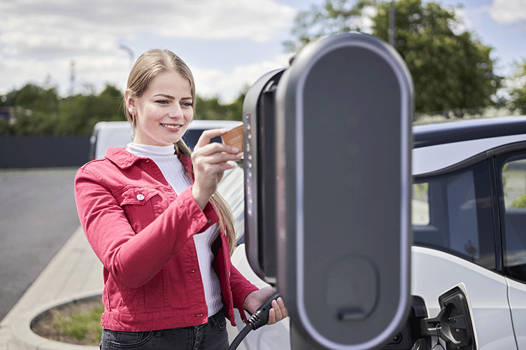 Frau mit RFID Karte an Compleo Ladestation für E-Auto