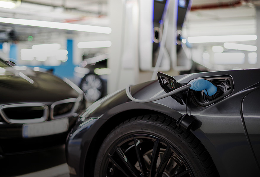 Elektroauto laden in der Tiefgarage Frau lädt an Wallbox für Elektroautos im Mietshaus